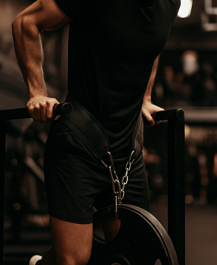 Das Bild zeigt einen Kraftsportler, der im Fitnessstudio Dips ausführt.