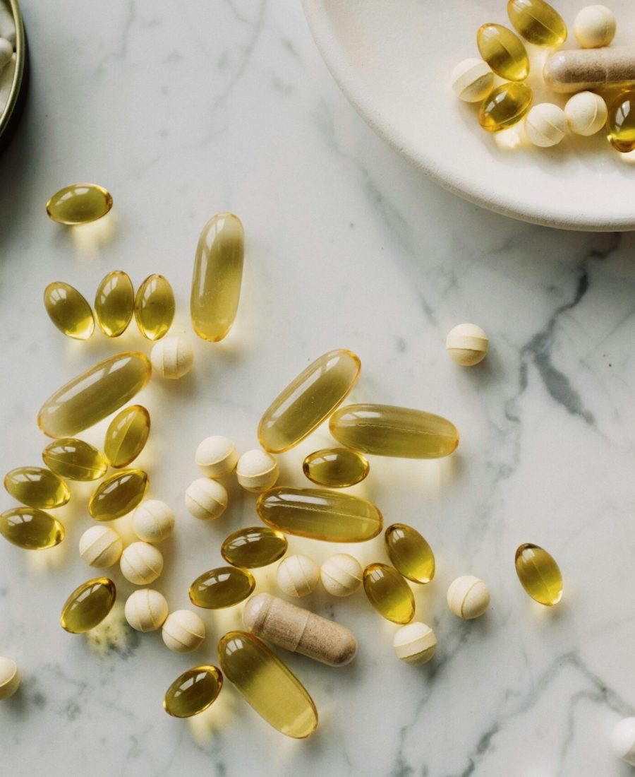 A collection of supplements and pills scattered on a marble surface, showcasing healthcare essentials.